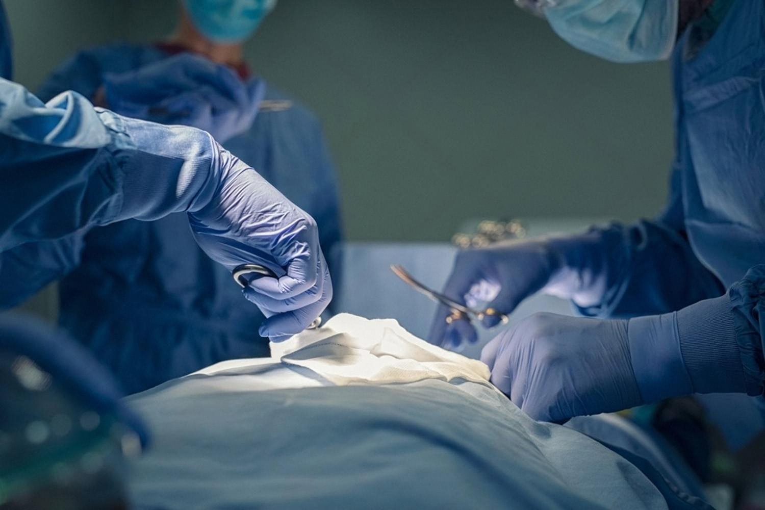 Open hernia surgery being performed with surgical instruments and sterile drapes